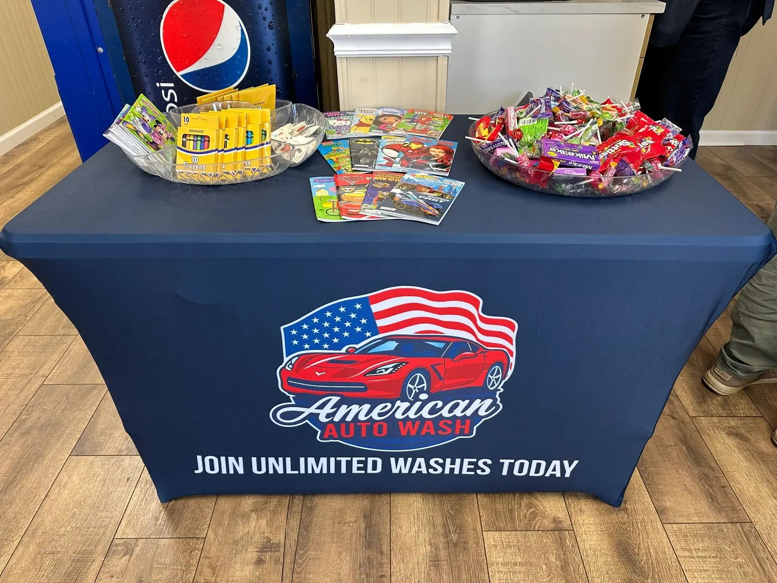 An American Auto Wash table with a Join Unlimited Washes Today banner